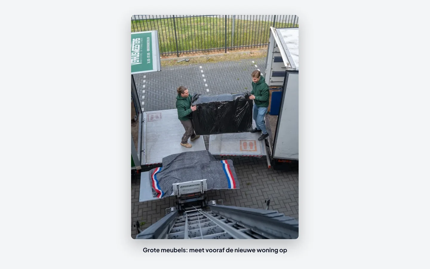 Verhuizers van VerhuisMeesters dragen een bank naar de verhuiswagen