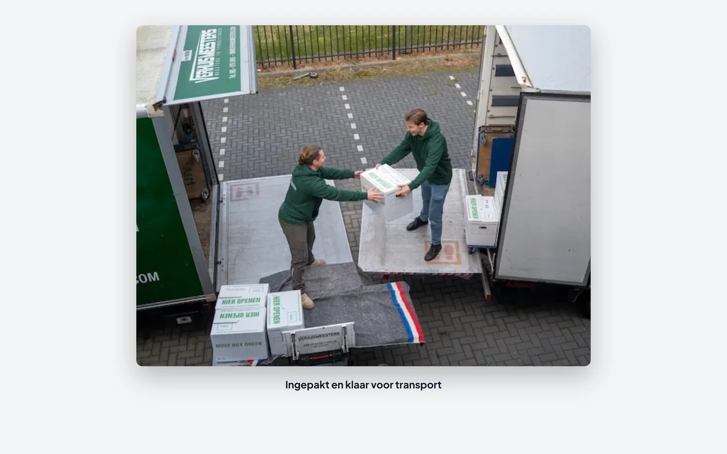 Verhuizers van VerhuisMeesters dragen ingepakte verhuisdozen naar de verhuiswagen