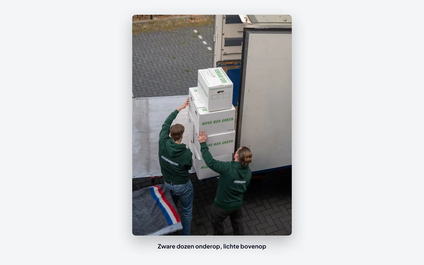 Verhuizers van VerhuisMeesters laden gestapelde verhuisdozen in de verhuiswagen