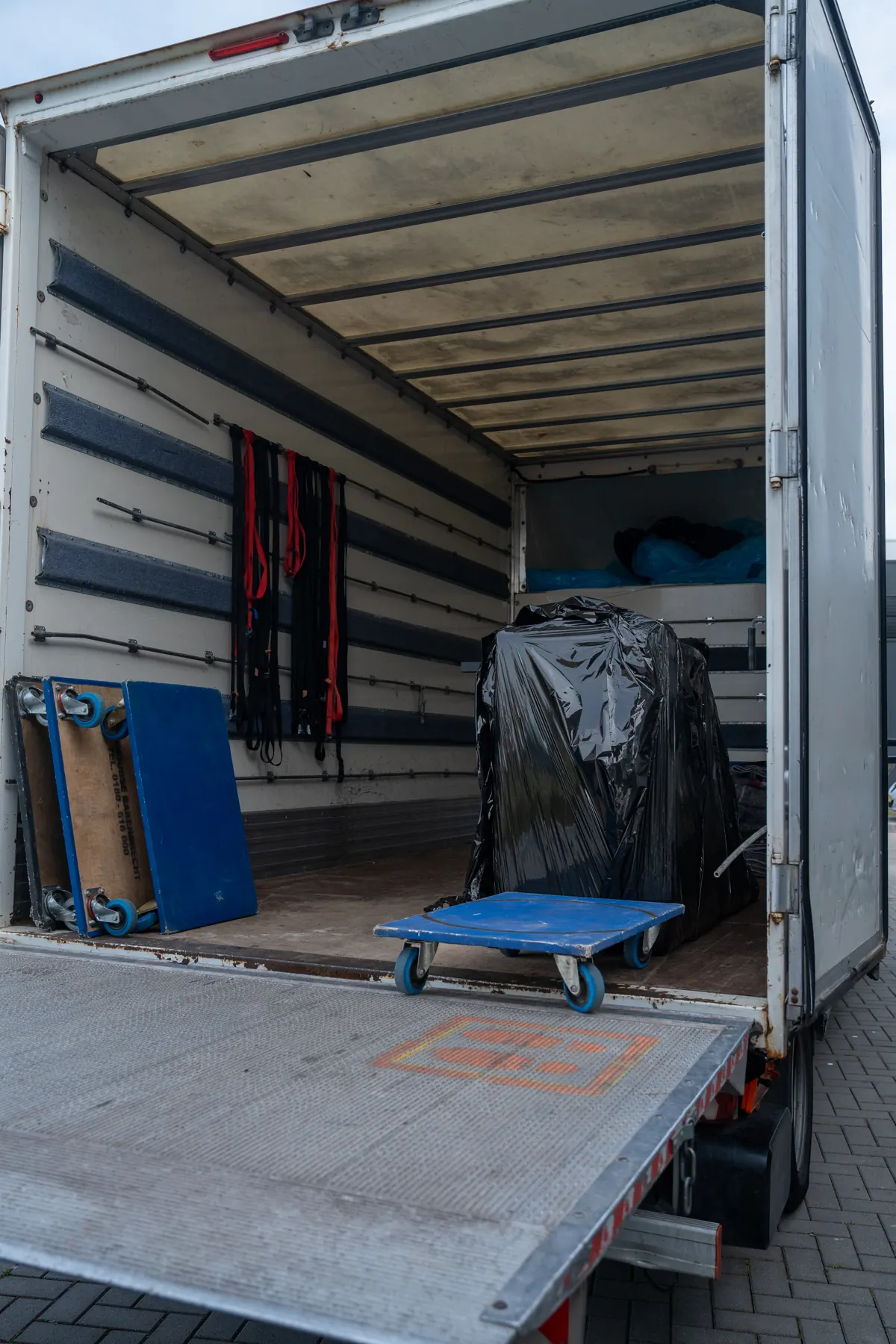 Laadruimte van de verhuiswagen met rolwagens en ingepakte meubels
